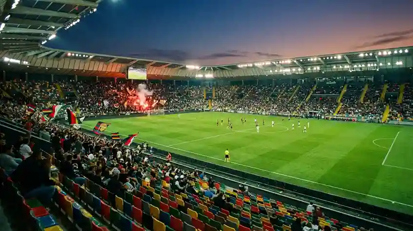 Stadio di Serie A italiano visto dalla tribuna con il campo da calcio in erba naturale illuminato